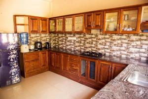 a kitchen with wooden cabinets and a refrigerator at The Nature in Tangalle