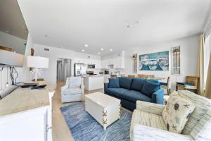 a living room with a blue couch and chairs at Sea Glass 404 by Youngs Suncoast in Gulf Shores