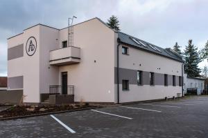 a white building with a parking lot in front of it at Apartmány Dalešice in Dalešice