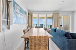 a living room with a blue couch and a table at Sea Glass 404 by Youngs Suncoast in Gulf Shores