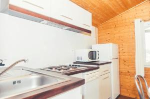 a kitchen with white appliances and a sink at Chalet 3 étoiles - Piscine - eebbhf in Beynat