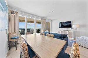 a living room with a table and a blue couch at Sea Glass 404 by Youngs Suncoast in Gulf Shores +47 photos