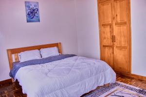 a bedroom with a bed and a wooden door at The Haven House in Nairobi