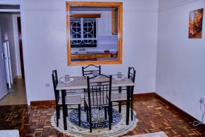a dining room table with chairs and a window at The Haven House in Nairobi