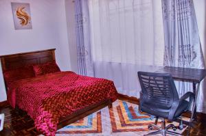 a bedroom with a bed and a desk and a chair at The Haven House in Nairobi