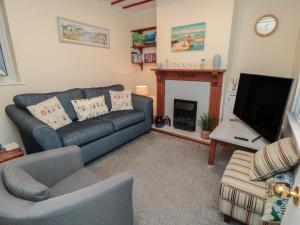 a living room with a couch and a tv at Seabreeze in Filey