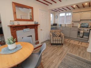a living room with a table and a fireplace at Seabreeze in Filey