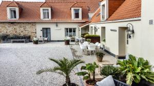 a courtyard with tables and chairs and plants at Le Chat Perché in Escalles