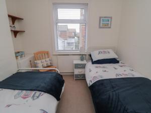 a bedroom with two beds and a window at Seabreeze in Filey