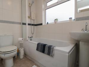 a bathroom with a toilet and a tub and a sink at Seabreeze in Filey
