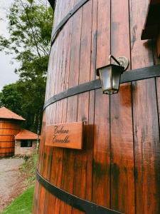 a sign on a wooden wall with a light on it at Pousada tanoeiro cabana Carvalho in Monte Belo +6 photos