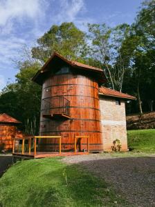 a cylindrical building with a large wooden silo at Pousada tanoeiro cabana Carvalho in Monte Belo