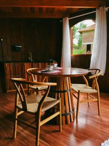 a wooden table and chairs in a room with a table at Pousada tanoeiro cabana Carvalho in Monte Belo