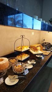 a buffet with several trays of food on a counter at Him Hotel in Iraí de Minas +21 photos