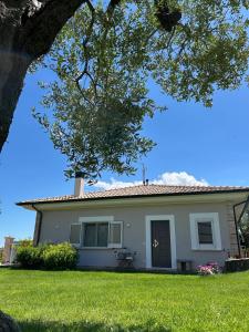 a white house with a tree in the foreground at Casa Adriano-Dimora per vacanze in Ripa Teatina