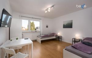 a white room with a bed and a table and a couch at BEGE APARTMENTS LoftWork in Lüdenscheid
