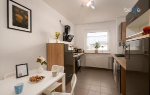 a small kitchen with a white table and a table and chairs at BEGE APARTMENTS LoftWork in Lüdenscheid +10 photos