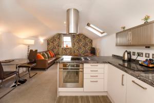 a kitchen with a stove and a living room at City Apartments - Reubens Court in York