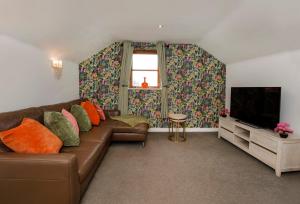 a living room with a brown couch and a television at City Apartments - Reubens Court in York