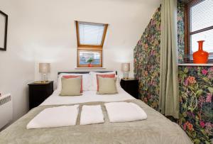a bedroom with a large white bed with two windows at City Apartments - Reubens Court in York