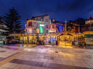 Ein Gebäude mit Weihnachtsbeleuchtung in einer Stadt bei Nacht in der Unterkunft Hotel Elit in Dewin