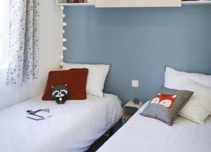 two twin beds in a room with blue walls at ZEcamping 4 étoiles animé piscine couverte club enfant mini golf dog friendly in La Faute-sur-Mer