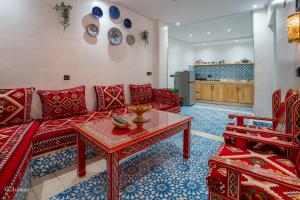 a living room with a red couch and a table at Dar jawhara in Chefchaouen