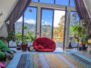 a room with a red chair in front of a window at У Потічка in Izki