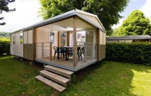 a tiny house with a dining table in a yard at ZEcamping 4 étoiles familial - parc aqua et soirées animées in Murol +22 photos
