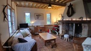 a living room with a couch and a fireplace at Gite des Trévignes in Cambremer