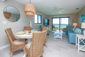 a living room with a table and chairs and a couch at Sandalfoot 5D3 - Oceanfront Sanibel Condo in Sanibel