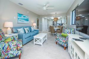 a living room with a blue couch and chairs at Sandalfoot 5D3 - Oceanfront Sanibel Condo in Sanibel