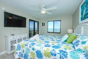 a bedroom with a bed and a flat screen tv at Sandalfoot 5D3 - Oceanfront Sanibel Condo in Sanibel +24 photos