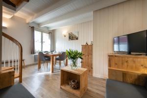 a living room with a television and a table at Le Chat Perché in Escalles