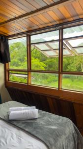 a bed in a room with a view of a window at Drop House Hostel - Surf & Skate - Itamambuca in Ubatuba +62 photos