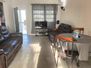 a living room with a couch and a table and a television at Brightridge Condos in Bridgetown