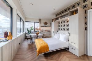 a bedroom with a large bed and a dining area at Seinhuis Post VI in Amersfoort
