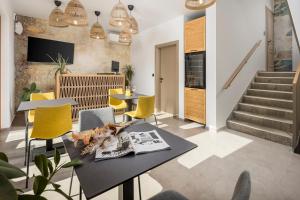 a living room with a table and yellow chairs at Pula Residence in Pula