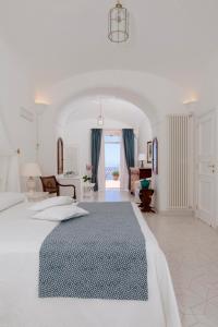 a white bedroom with a large bed and a living room at La Bizantina Luxury Villa in Positano +66 photos