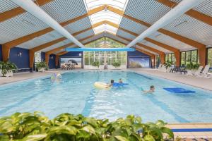 a group of people playing in a swimming pool at Zee aan Geluk in Sint Maartensvlotbrug