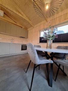 a dining room with a table and chairs and a kitchen at Zee aan Geluk in Sint Maartensvlotbrug