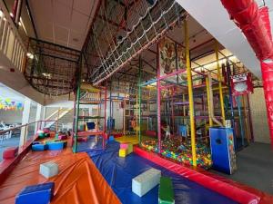 a large room with a play area with a playground at Zee aan Geluk in Sint Maartensvlotbrug