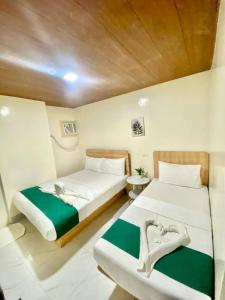 a bedroom with two beds and a wooden ceiling at RedDoorz at Urban Hotel in Zamboanga