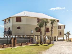 a large building with palm trees in front of it at Summer Salt 3 East by Youngs Suncoast in Orange Beach