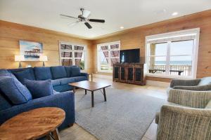 a living room with a blue couch and a tv at Summer Salt 3 East by Youngs Suncoast in Orange Beach