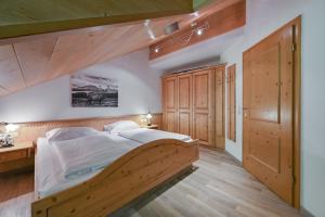 a bedroom with a wooden bed and wooden floors at Residenz Sonnenhang I in Füssen +93 photos