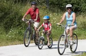 a man and a woman riding bikes with a child at ZEcamping 4 étoiles familial - parc aqua et soirées animées in Murol