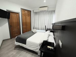 a hotel room with a bed and a window at Hostal Doña Isabel in Majadahonda