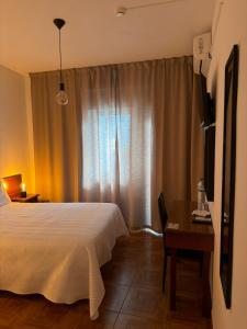 a bedroom with a bed and a table and a window at Romeu in Quarteira