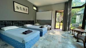 a hotel room with two beds and a table and chairs at Bulan Anda Resort in Ban Hua Laem